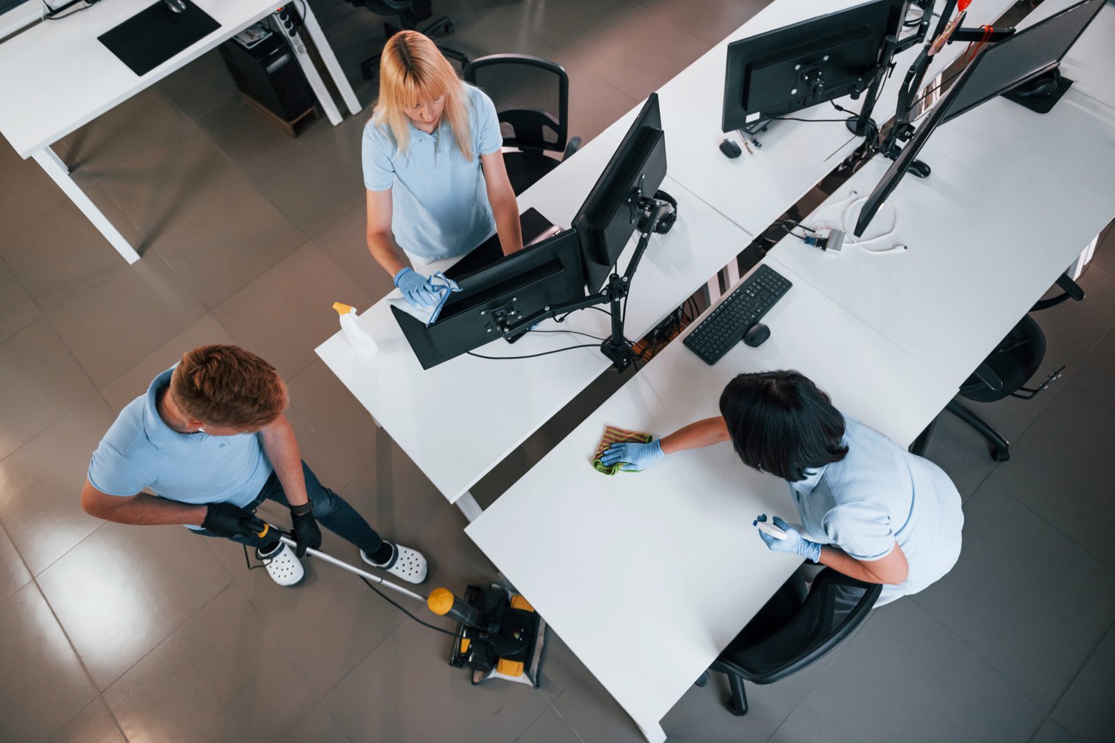Top view. Group of workers clean modern office together at daytime